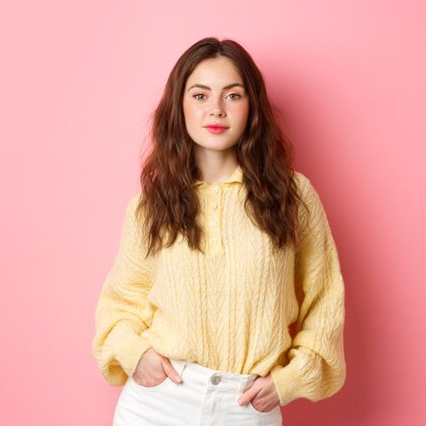 Selbstvertrauen stärken: Junge, selbstbewusste Frau mit gelbem Pullover