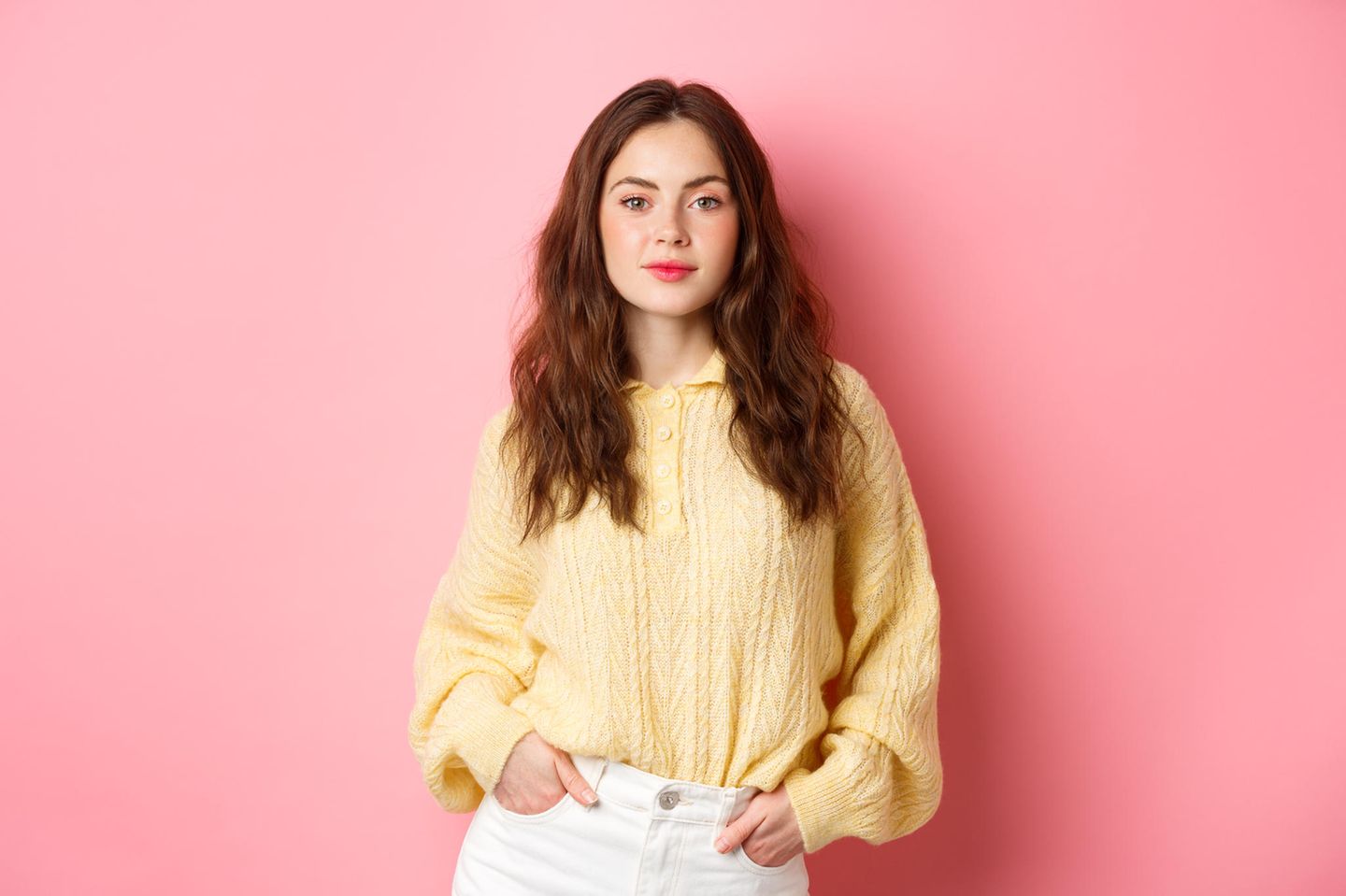 Selbstvertrauen stärken: Junge, selbstbewusste Frau mit gelbem Pullover