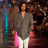 Jared Leto spielt im unter Modefans heiß ersehnten Film "House of Gucci" eine der Hauptrollen, und so darf er auf dem Runway der Love Parade nicht fehlen. In Oversize-Jackett und geschnürter Lederhose schreitet er über den Runway.