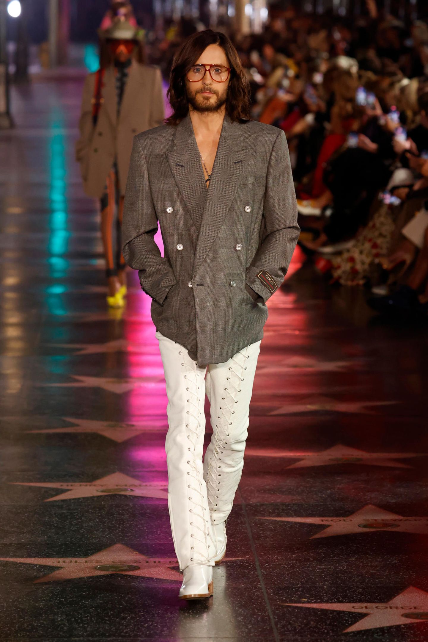 Jared Leto spielt im unter Modefans heiß ersehnten Film "House of Gucci" eine der Hauptrollen, und so darf er auf dem Runway der Love Parade nicht fehlen. In Oversize-Jackett und geschnürter Lederhose schreitet er über den Runway.