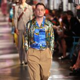 Noch mehr Hollywood-Glamour bringt Macaulay Culkin auf den Runway. Er trägt einen typischen Gucci-Mix aus Satinhemd, Satinjacke und brauner Anzughose.