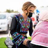 Königin Rania schüttelt die Hand einer Frau.