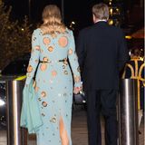 Auch die Rückenansicht des Kleides ist ein Hingucker. Neben zahlreichen Cut-Outs springt sofort der lange Beinschlitz ins Auge. Das Gold, das bereits im Kleid vorkommt, greift Königin Máxima mit ihren Sandalen mit Blockabsatz von Gianvito Rossi wieder auf. 