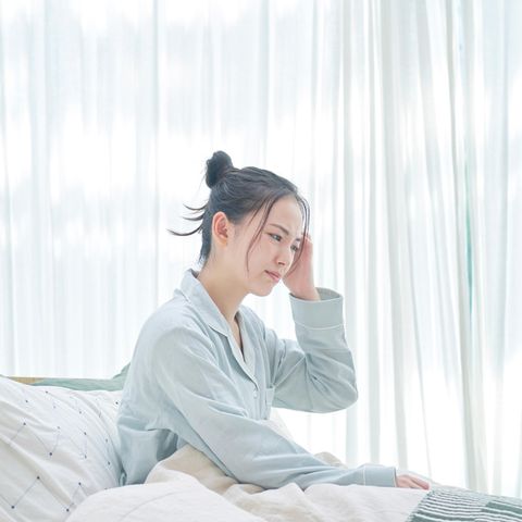 Müde Frau im Bett: Diese 5 Dinge passieren, wenn Sie zu wenig schlafen
