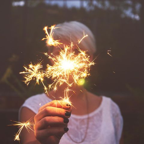 Horoskop: Junge Frau mit Funken-Feuerwerk