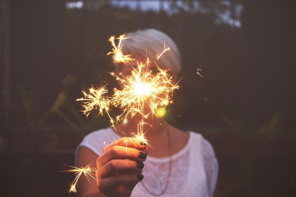 Horoskop: Junge Frau mit Funken-Feuerwerk