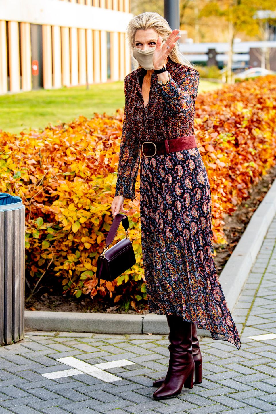 Königin Máxima zeigt sich bei dem Besuch eines Krankenhauses in einem bunten Herbstlook. Sie kombiniert ein Chiffon-Midikleid mit Paisley-Print von Altuzarra mit einer Schultertasche aus Leder von Wandler. Dazu trägt die Königin der Niederlande kniehohe Lederstiefel des italienischen Designers Gianvito Rossi.