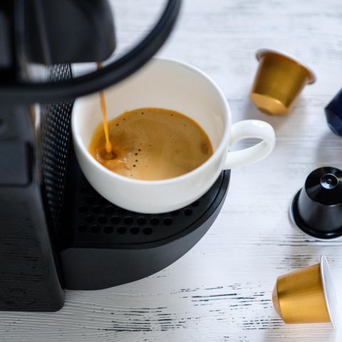 Espressovorbereitung. Kapselkaffeemaschine, daneben Kapseln