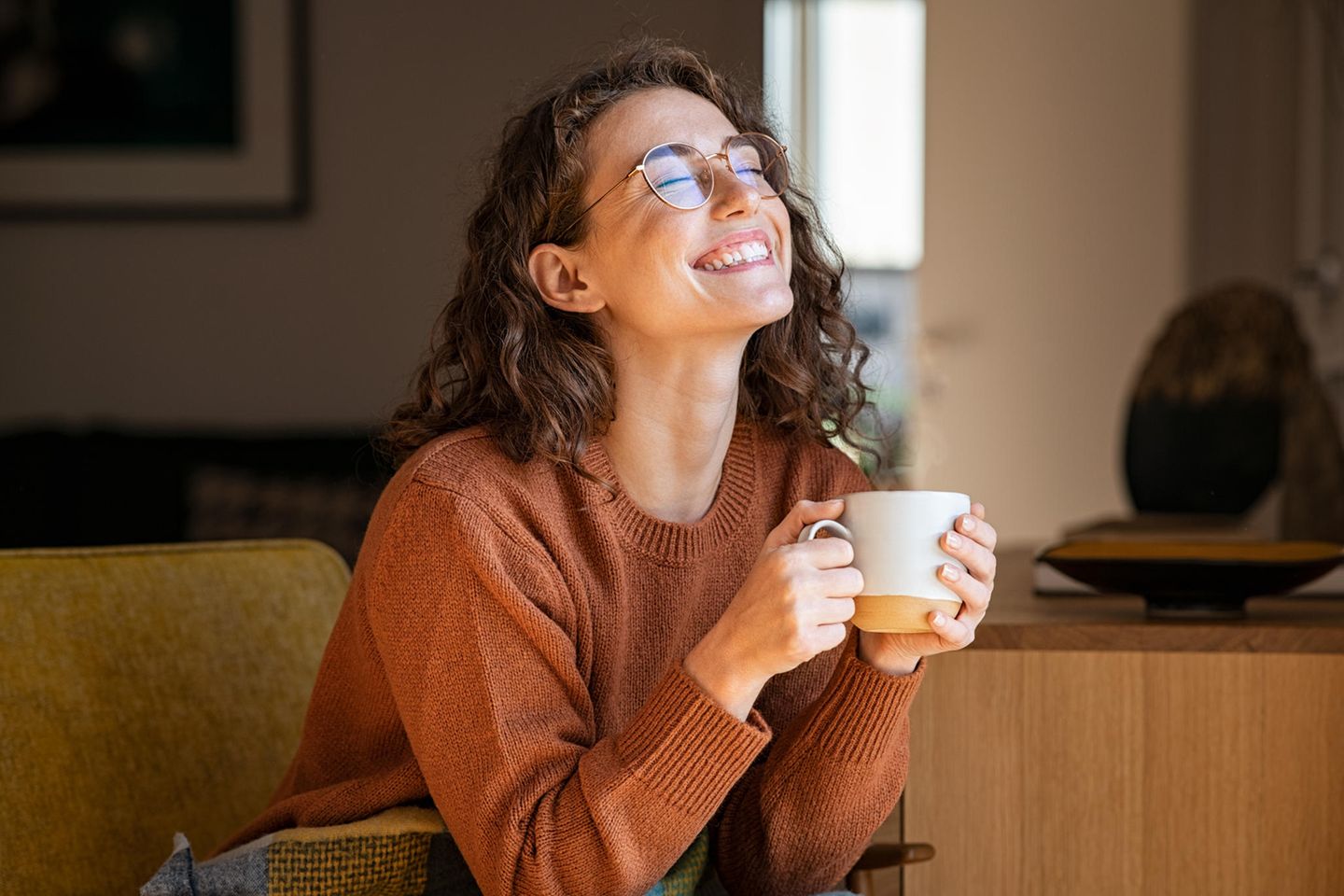 Horoskop: Lachende Frau mit Teetasse in den Händen