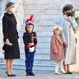 Die Looks von Prinzessin Caroline und Prinzessin Stephanie sind deutlich weniger spektakulär. Caroline trägt ein elegantes Bouclé-Ensemble von Chanel in schwarz, Stephanie erscheint im hellgrauen Oversize-Mantel.