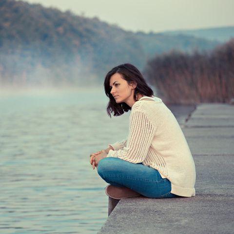 Horoskop: Frau blickt melancholisch auf See