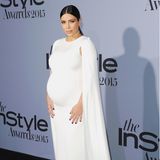 Im weißen Cape-Dress von Valentino zeigt Kim Kardashian bei den InStyle Awards 2015, wie elegant Schwangerschaftslooks sein können.