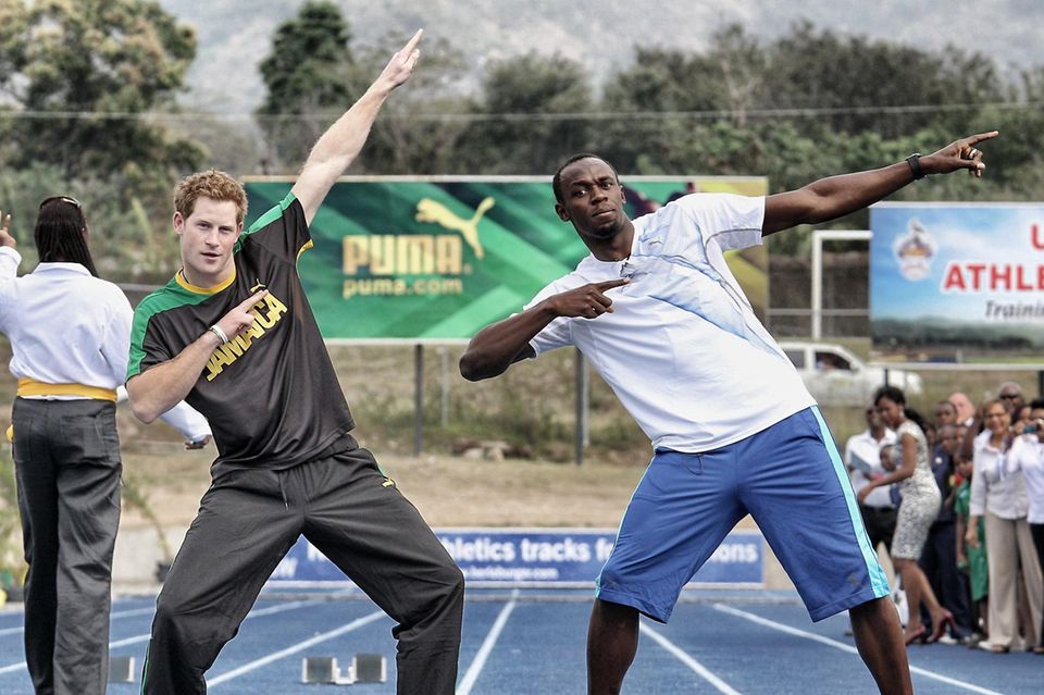 Usain Bolt: Prinz Harry und Usain Bolt in der typischen Sieger-Pose des Sprinters nach einem Wettrennen in Jamaika Prinz Harry und Usain Bolt in der typischen Sieger-Pose des Sprinters nach einem Wettrennen in Jamaika