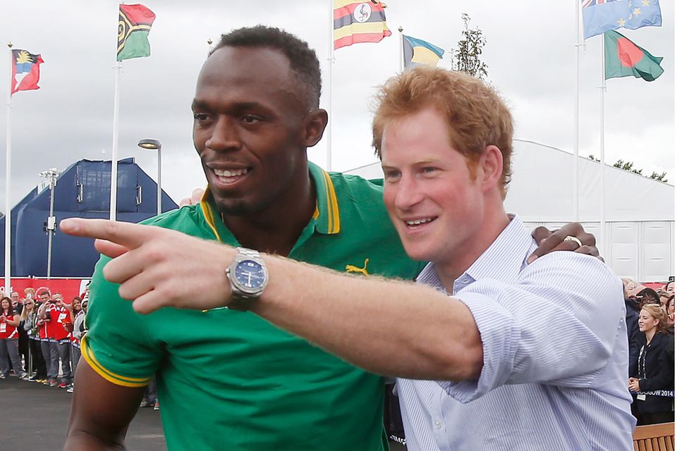 Usain Bolt und Prinz Harry 2014 beim Besuch des "Commonwealth Games Village" in Glasgow, Schottland