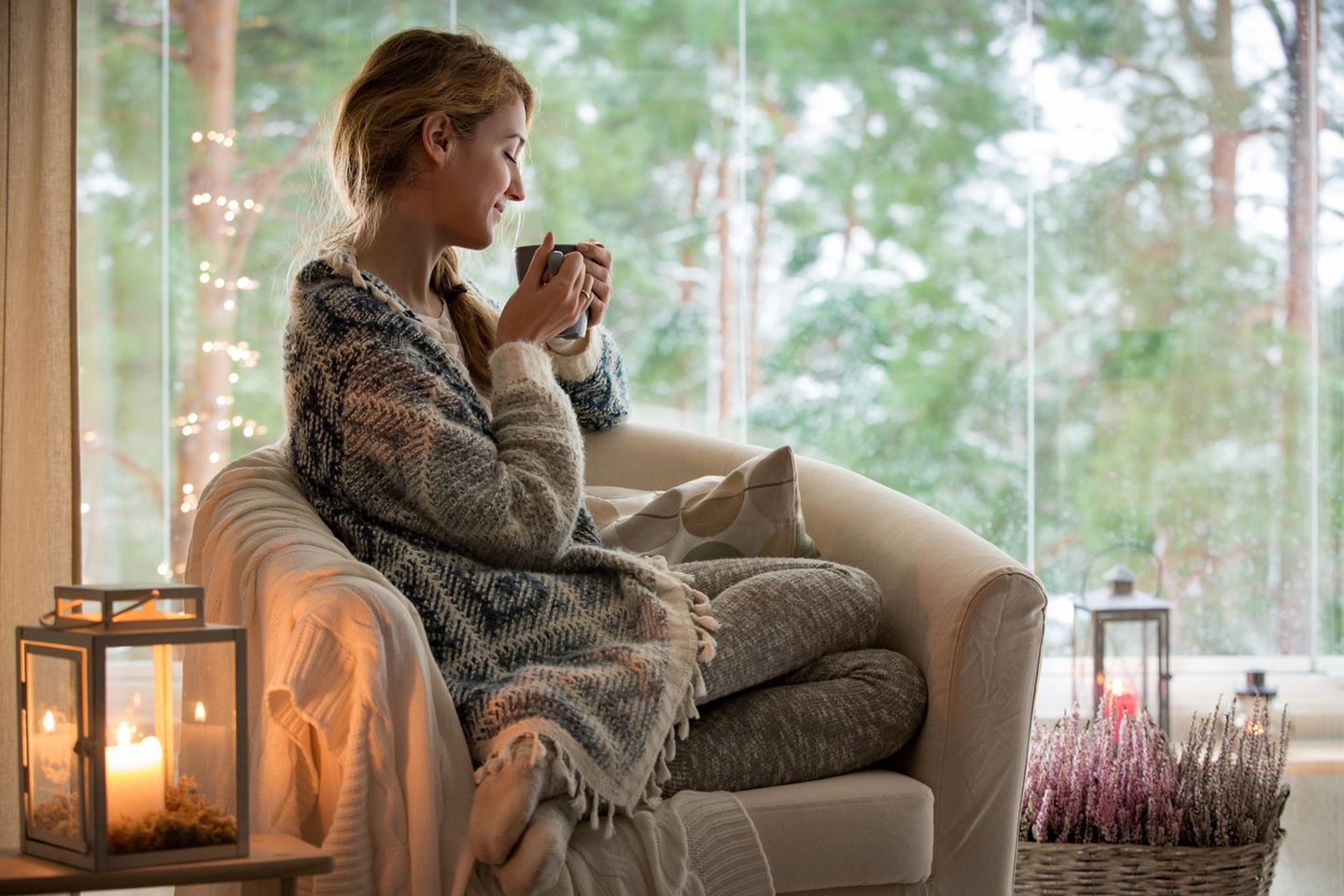 Horoskop: Frau mit Tasse auf dem Sofa