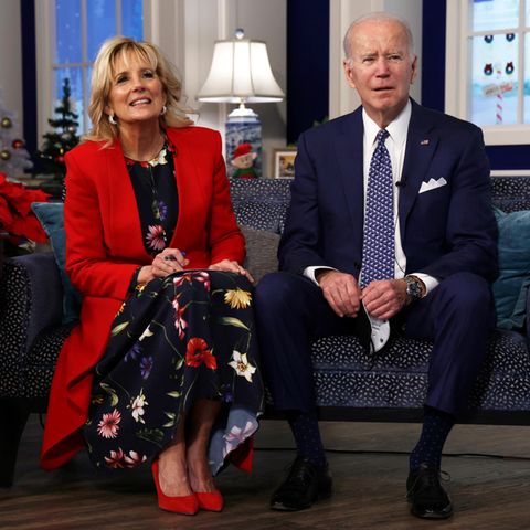 Joe Biden und Dr. Jill Biden nehmen am 24. Dezember an einer Veranstaltung in Washington teil. Die First Lady verleiht ihrem sommerlichen Blumenkleid mit dem roten langen Mantel einen weihnachtlichen Touch. 