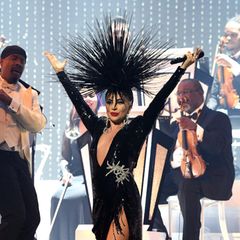 Lady Gaga ist für ihre besonderen Outfits bekannt, vor allem auf der Bühne. In Las Vegas bei ihrer "JAZZ & PIANO"-Show präsentiert sich die Sängerin in einer schwarzen Traumrobe aus Glitzer. Skurril wird ihr Look durch ihre Kopfbedeckung, die mit den ganzen spitzen Stacheln eher gefährlich und weniger elegant aussieht. 