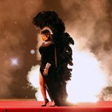 Wenn Cardi B die Bühne betritt, ist ein besonderes Outfit garantiert. Bei den American Music Awards tritt die Sängerin in einem schwarzen langen Kleid mit einem sexy Schlitz von Alexandre Vauthier auf. Damit der Look besonders auffällt, trägt sie eine riesige, mit Federn geschmückte Kopfbedeckung, die bis zum Boden reicht. 