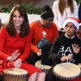 Die Herzogin hat ein großes Herz und liebt ihre Charity Arbeit. Hier trommelt sie mit Kindern des Anna Freud Centers in einem roten, weihnachtlichen Kleid um die Wette. 