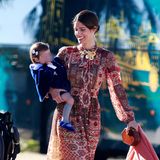 Herzogin Sofia, hier mit Töchterchen Rosario in Blau, bezaubert in einem auffälligen Schluppenblusen-Kleid des spanischen Labels Leyre Doueil. Die Pumps von Flor de Asoka, eine stylische Holzkästchen-Clutch und ein farblich passender Seidenschal machen den Look der royalen Hochzeitsgästin perfekt. 