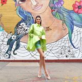 Der Trendschuh gibt es in verschiedensten Varianten und so wird das transparente Modell von Amina Muaddi auch mit glänzender Schnalle getragen. Kendall Jenner trägt den Schuh der Stunde zu einer neongrünen Bluse und einem kurzen gemusterten Rock. 