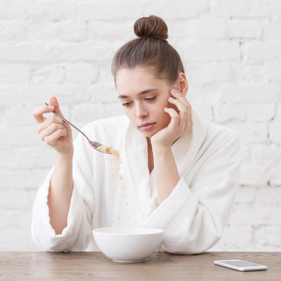 Frau isst unglücklich: 5 Abnehmfallen, die Ihren Stoffwechsel hemmen