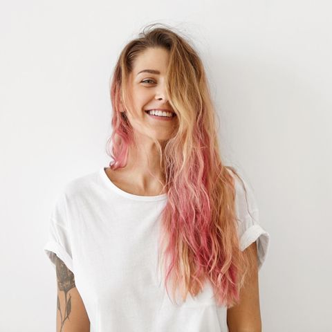 Horoskop: Frau mit rosa Haaren lächelt