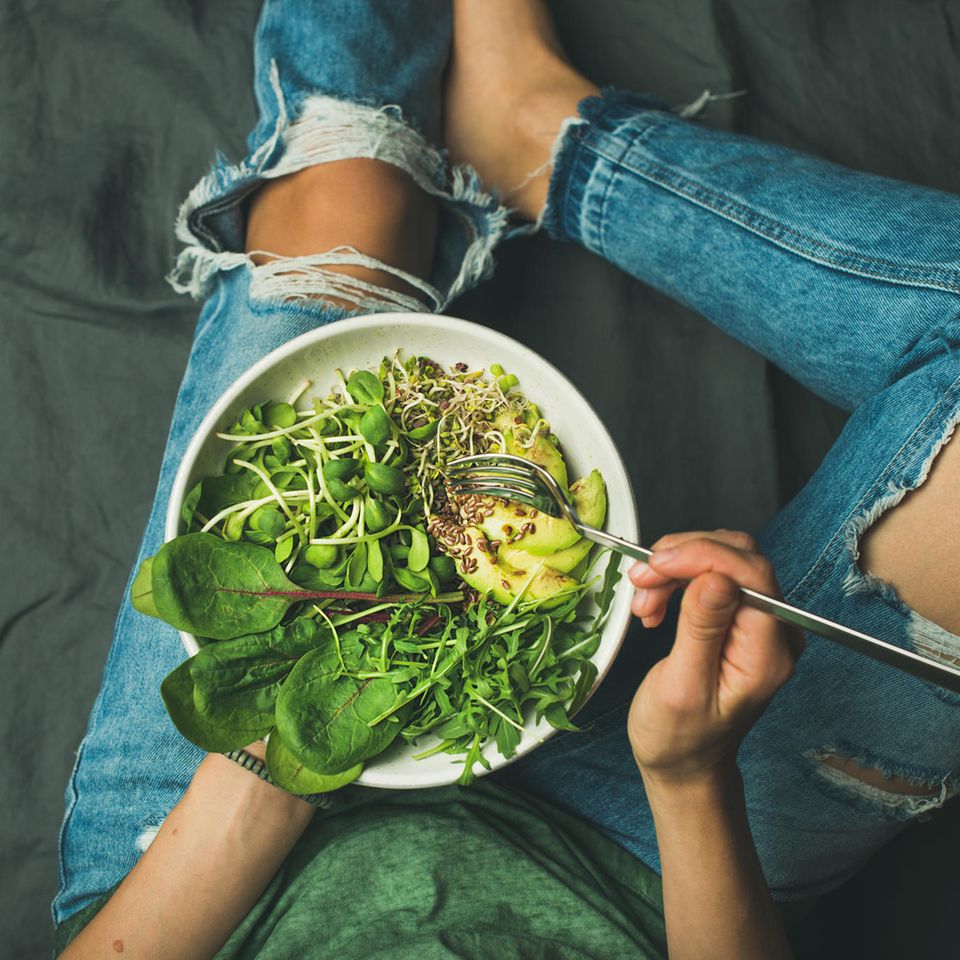Frau isst Salat: Warum Sie mit veganer Ernährung abnehmen, obwohl Sie nicht weniger Kalorien essen
