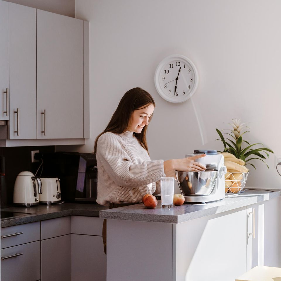 brünette junge Frau in einer Küche mit einer Küchenmaschine