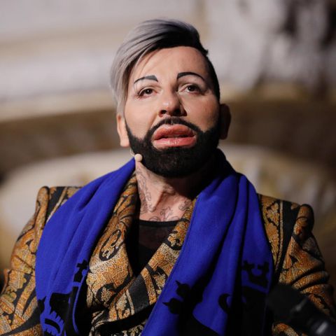 Harald Glööckler sitzt vor einem Altar in der Kirche.