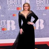 Adele präsentiert sich bei den diesjährigen Brit Awards in einer wahren Traumrobe. Das schwarze, elegante Kleid mit einem atemberaubenden V-Ausschnitt von Armani Privé zieht alle Blicke auf sich. Das Kleid sorgt für eine wunderschöne Silhouette und besticht durch die durchsichtigen Details. Dazu die auffälligen Ohrringe und die sehr klassisch gestylten Haare mit gelockten Spitzen und der perfekte Adele-Look steht. 