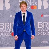 Ed Sheeran setzt bei seinem Look auf ein kräftiges Blau und wählt einen Samtanzug von Etro. Passend dazu trägt er einen dunkelblaue Krawatte mit Paisleymuster. 