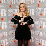Adele gewinnt bei den Brit Awards gleich drei Preise und posiert fröhlich mit ihren Auszeichnungen. Auf dem schönen Foto trägt sie ein kurzes Kleid, welches mindestens genau so schön wie ihr erster Look ist. Das schulterfreie Samtkleid kombiniert die Sängerin mit einer dunklen Strumpfhose und High Heels mit Schnalle. 