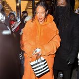Für das Beauty-Shopping bei Sephora hüllt sich Sängerin Rihanna in einen orangefarbenen Oversize-Mantel. Er ist so weit, dass er den wachsenden Babybauch von Rihanna kaschiert, denn zu diesem Zeitpunkt ist sie bereits schwanger. Auf die High Heels verzichtet sie dennoch nicht.