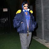 Rihanna führt ihren Schwangerschaftsstyle-Marathon fort und setzt ihren Babybauch auch zum Super Bowl extravagant in Szene. Mühelos cool zieht sie im Rahmen des Events die Blicke in einer durchsichtigen blauen Bluse und passendem Kopftuch auf sich. Weitere Highlights von Rihannas Outfit: ein royalblauer Spitzen-BH sowie eine weite Bomberjacke samt kanarienvogelgelber Details. Lange Ketten, mittlerweile schon ein Signature-Piece bei den Schwangerschaftslooks der Sängerin, kommen ebenfalls zum Einsatz. Die leicht zerrissene graue Jeans rundet ihren sportlich-schicken Super Bowl-Style ab.