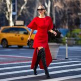 Streetstyle-Lady in Red: Leonie Hanne begeistert auf dem Weg zur Show von Carolina Herrera in einem asymmetrischen Power-Look mit ledernen Overknees. 