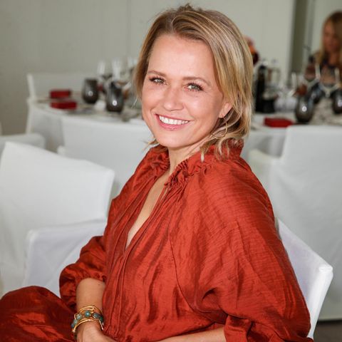 Nova Meierhenrich sitzt auf einem Stuhl und posiert für die Fotografin.
