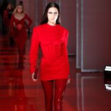 Die Schwestern Hadid sind ebenfalls Teil der Show von Donatella Versace. Bella Hadid trägt auf dem Catwalk ein hochgeschlossenes Minikleid, das mit einer engen Korsage versehen wurde. Dunkles Make-up und eine Latex-Pants geben dem Look etwas Verruchtes. 