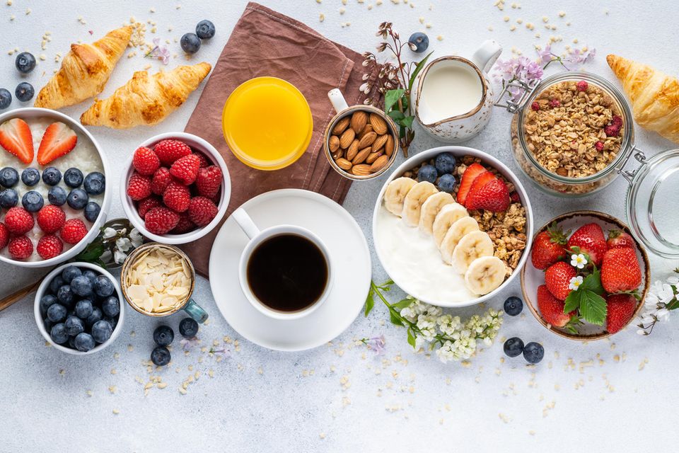 Großes Frühstück mit Müsli, Joghurt, Kaffee, Obst, Croissants: Warum wir morgens viel essen sollten