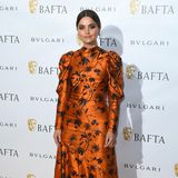 Ob das Zufall ist? Passend zum orangefarbenen Teppich, erscheint auch Schauspielerin Jenna Coleman in einer Robe mit Puffärmeln und Blumen-Muster in Orange. 