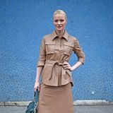 Franziska Knuppe trägt zur Show von Sofia Ilmonen eine beigefarbene Kombi aus tailliertem Hemd und Rock. Dazu kombiniert sie Overknees aus Wildleder.