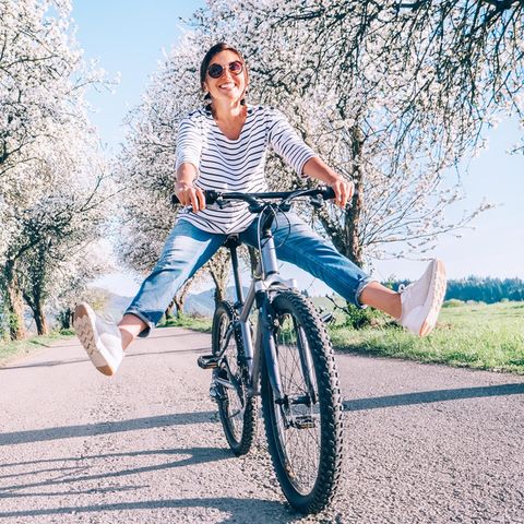 Glückliche Frau auf dem Fahrrad: 4 Tipps für positive Gedanken und ein starkes Mindset