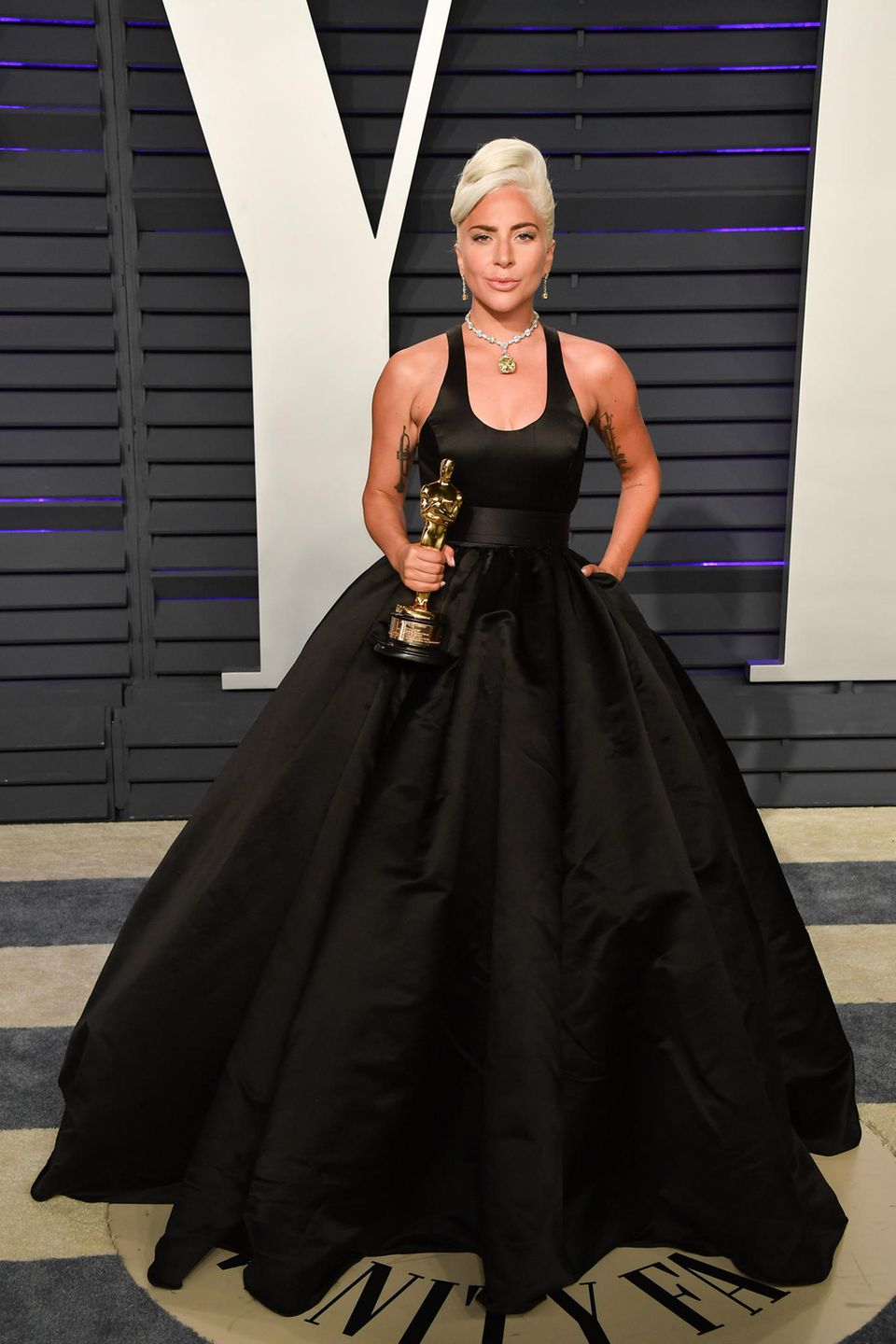Bei der Vanity Fair Oscar Party erkennen wir die alte Gaga gar nicht wieder: In einem zeitlosen Brandon Maxwell-Kleid sieht sie aus wie eine schicke Power-Frau. Typisch Gaga sind nur noch ihre platinblonden Haare. Statt als Bob mit Pony aber elegant hochgesteckt.