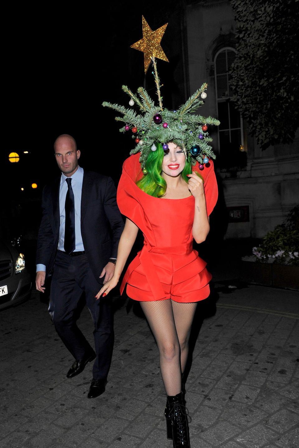 Wie ein Chamäleon schlüpft Lady Gaga in jede Rolle: Im winterlichen London verwandelt sie sich glatt selbst in einen Tannenbaum. Auf grünen Haaren trägt sie echte Tannenzweige, geschmückt mit bunten Weihnachtskugeln.