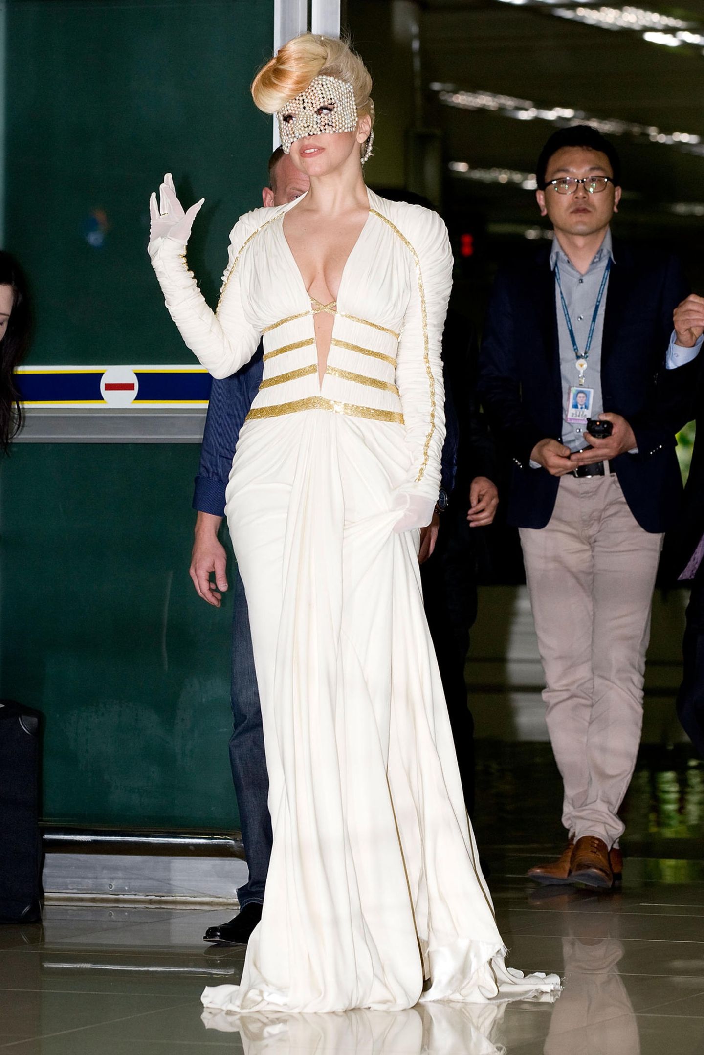 Gaga kann auch sexy! So trägt sie bei ihrer Ankunft in Seoul eine Versace Robe mit passender Perlen-Maske. In dem weißen Maxi-Kleid mit goldenen Applikationen sieht sie aus, wie eine griechische Göttin.