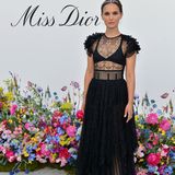 Natalie Portman besucht das "Dior"-Event in einem schwarzen Spitzenkleid im "Black Swan"-Stil. Dazu trägt sie einen Haarband mit Blumen.