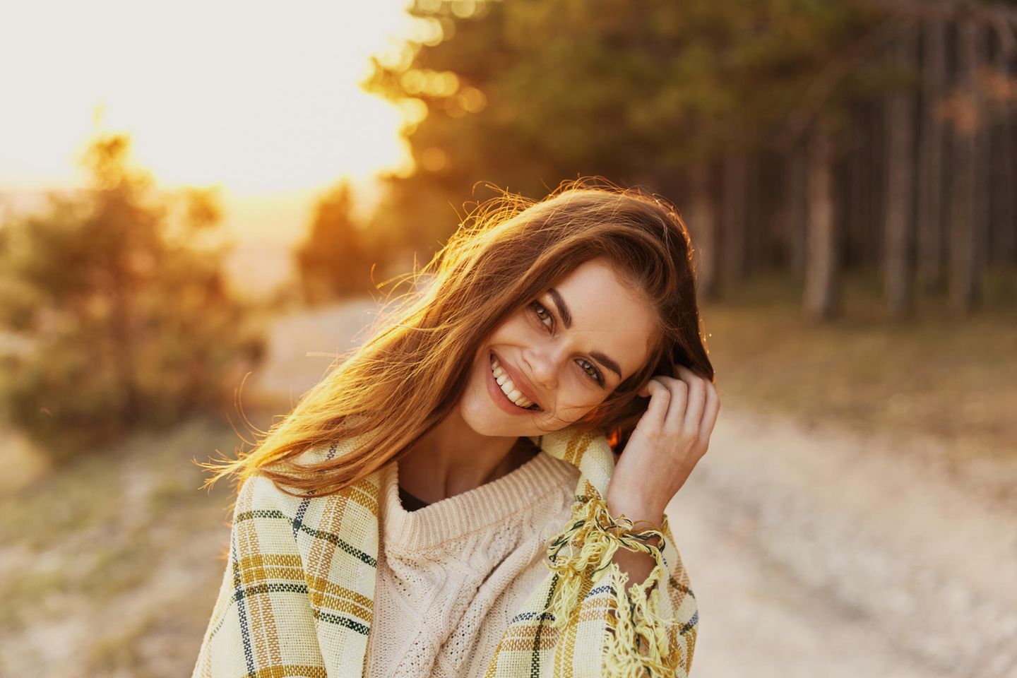 Glücklicher Single: Frau die im Sonnenuntergang glücklich lächelt