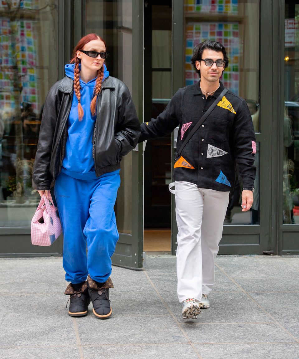 Beim Verlassen ihres Hotels in New York hält Schauspielerin Sophie Turner ihren Babybauch im blauen Hoodie gut versteckt. Die "Game of Thrones"-Darstellerin und ihr Ehemann Joe Jonas erwarten ihr zweites Kind und glänzen im harmonisch-sportlichen Date-Look. Über Hoodie und Hose trägt die 26-Jährige außerdem Lederjacke im Oversize-Look, Designer-Stiefel und eine rosa-karierte Handtasche, Joe ergänzt das stylische Duo mit farblich abgestimmten Patches.