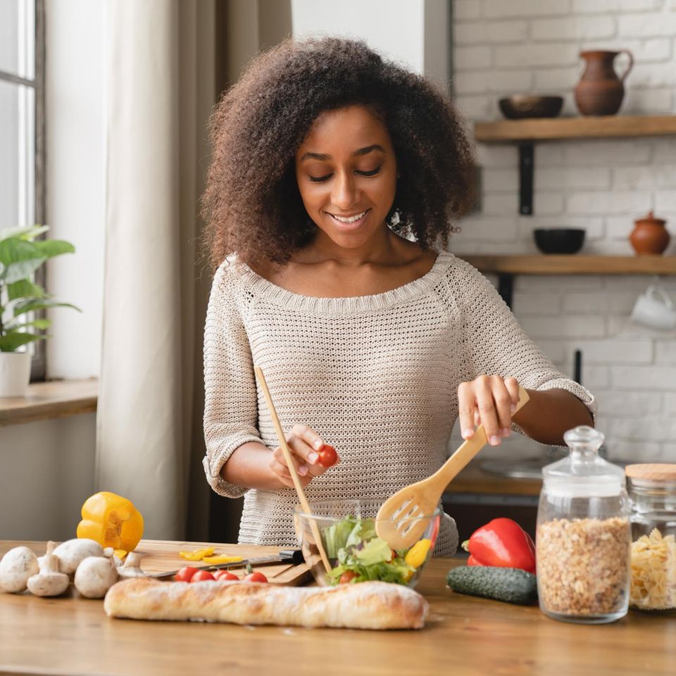 Frau kocht vegan mit viel Gemüse