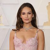 Lilly James greift auf dem Red Carpet der 94. Oscars das Rosa ihres Kleides auf und setzt auf zartrosa Lidschatten sowie passenden Lippenstift. Die Haare bleiben in sanften Wellen.